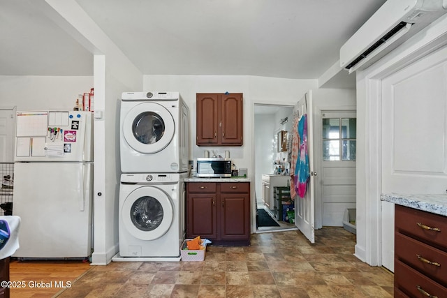 laundry area featuring a wall mounted air conditioner and stacked washer and clothes dryer