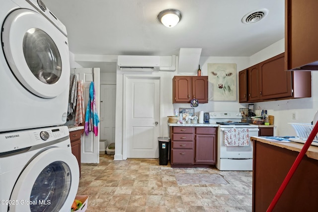 kitchen featuring electric stove, stacked washer and dryer, and a wall mounted AC