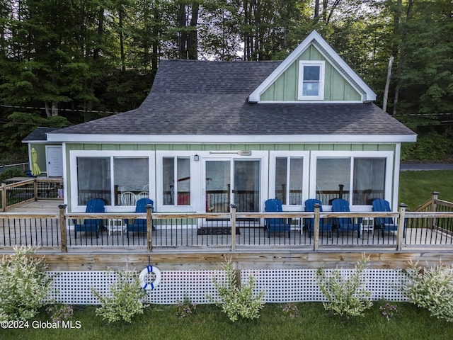 back of property featuring a wooden deck and a sunroom