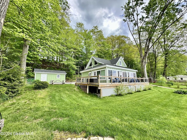 back of house featuring a wooden deck, a yard, and a shed