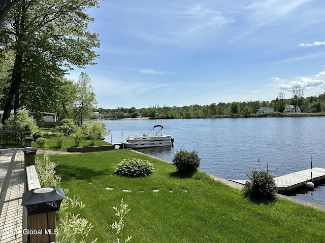 view of dock with a yard and a water view