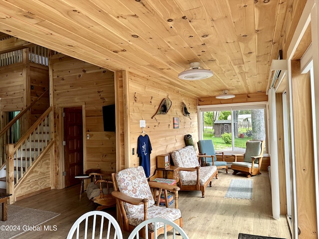 living area with wood ceiling, lofted ceiling, wooden walls, and light hardwood / wood-style floors