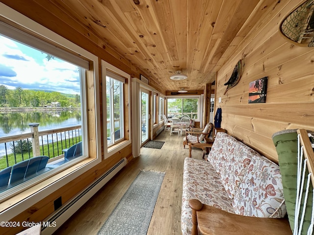 sunroom with a water view, baseboard heating, and wooden ceiling