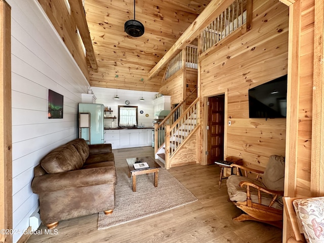 living room featuring high vaulted ceiling, light wood-type flooring, wooden walls, and wood ceiling