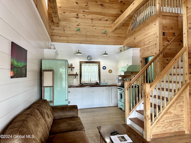 living room featuring wood ceiling, wood walls, high vaulted ceiling, and light wood-type flooring