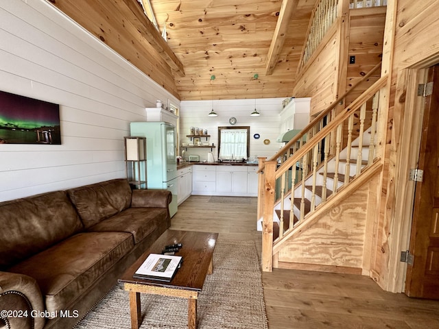 living room featuring vaulted ceiling, wooden ceiling, wooden walls, and light hardwood / wood-style floors