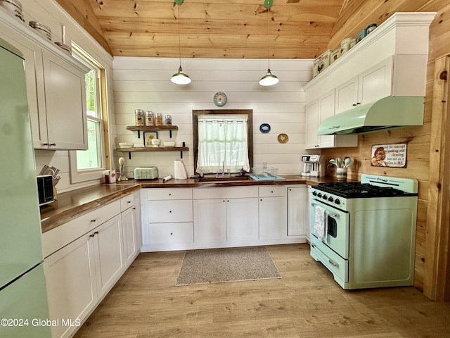 kitchen featuring decorative light fixtures, sink, white cabinets, wood ceiling, and gas range gas stove