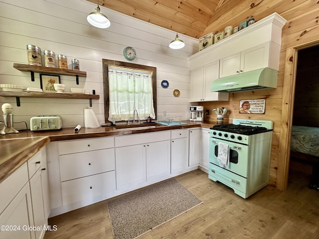 kitchen featuring white cabinetry, sink, pendant lighting, and white gas stove