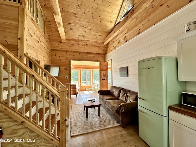 living room featuring high vaulted ceiling, wooden walls, wooden ceiling, and light hardwood / wood-style floors