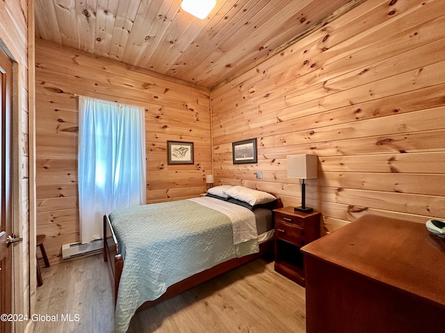 bedroom featuring a baseboard heating unit, wooden ceiling, wooden walls, and light hardwood / wood-style flooring