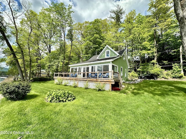 back of house with a wooden deck and a lawn