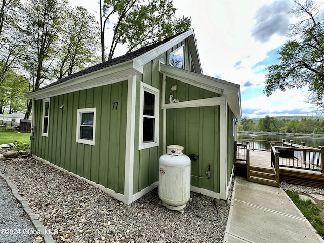 view of property exterior featuring a deck with water view