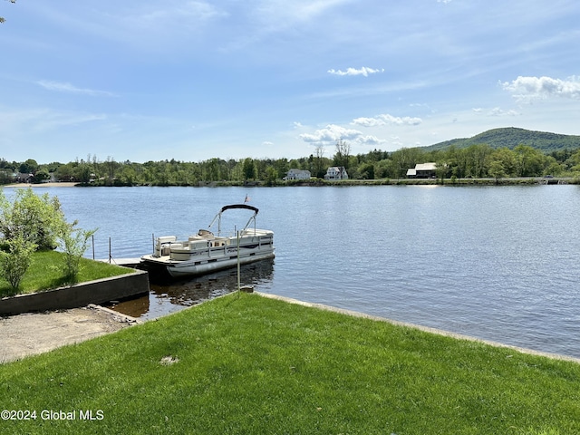 dock area featuring a water and mountain view and a lawn