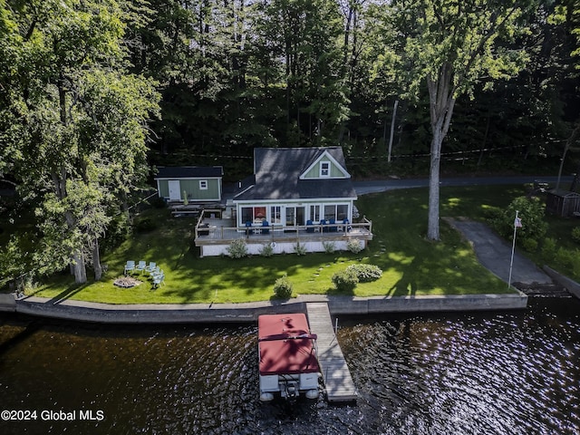 back of property with a deck with water view and a yard