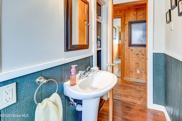 bathroom with hardwood / wood-style floors and wooden walls