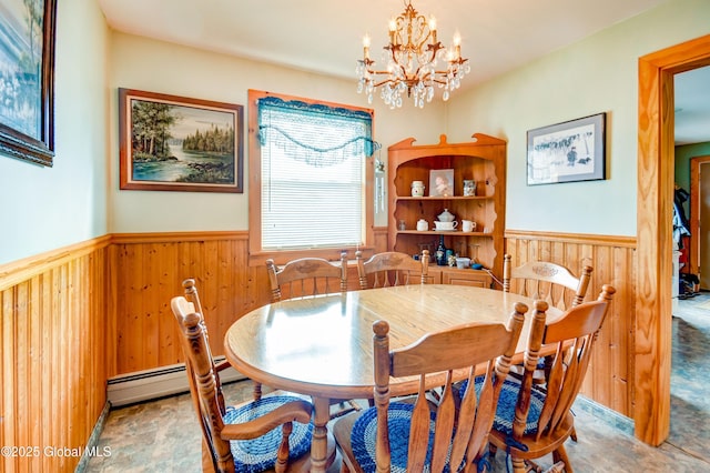 dining room featuring baseboard heating, wooden walls, and a notable chandelier