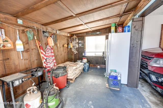 interior space with white fridge and wooden walls