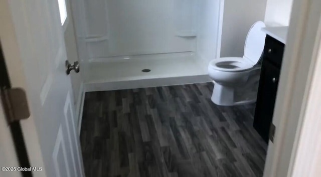 bathroom featuring vanity, wood-type flooring, toilet, and walk in shower