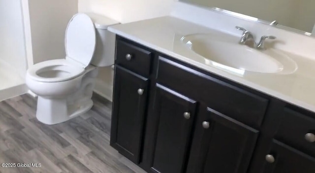 bathroom featuring hardwood / wood-style flooring, vanity, and toilet