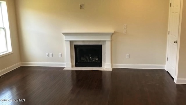 unfurnished living room with a fireplace and dark hardwood / wood-style flooring