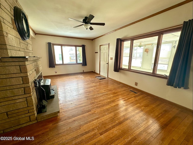 unfurnished living room featuring hardwood / wood-style floors, ornamental molding, and ceiling fan