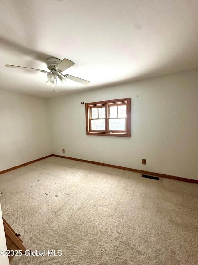 carpeted spare room with ceiling fan