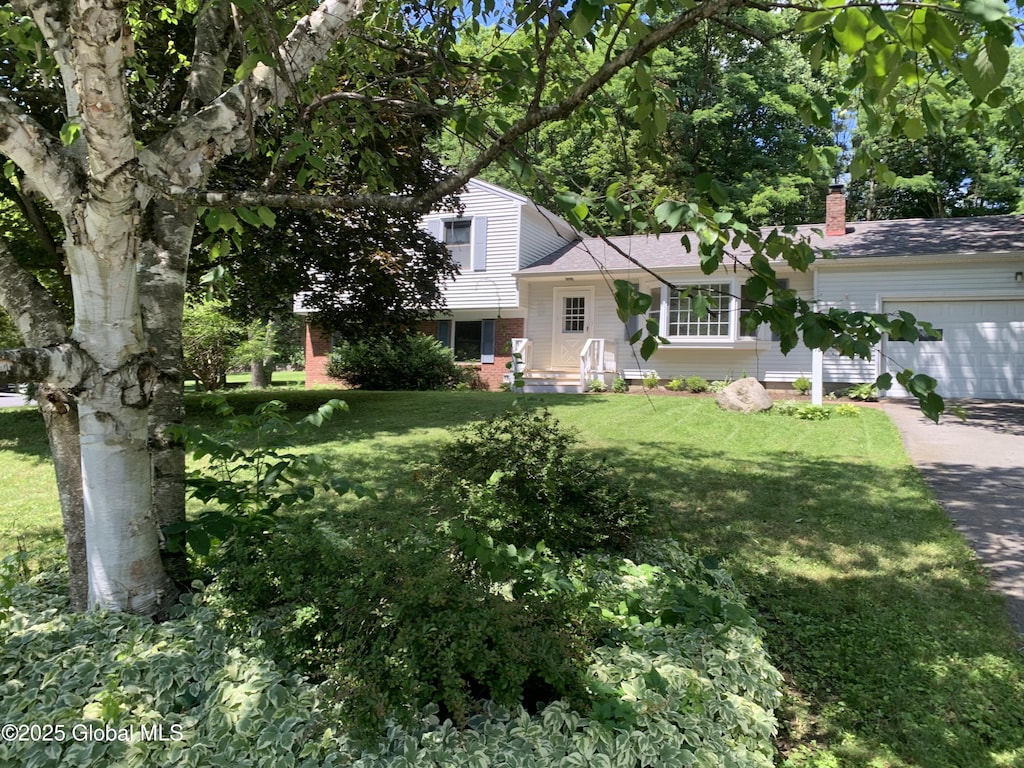 split level home featuring a garage and a front lawn