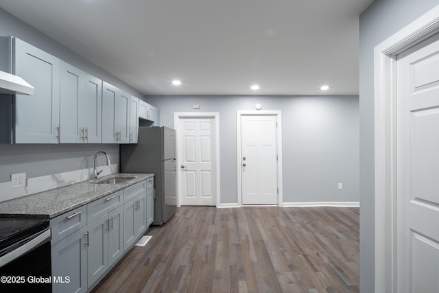 kitchen featuring sink, stainless steel fridge, light hardwood / wood-style floors, black range with electric cooktop, and light stone countertops