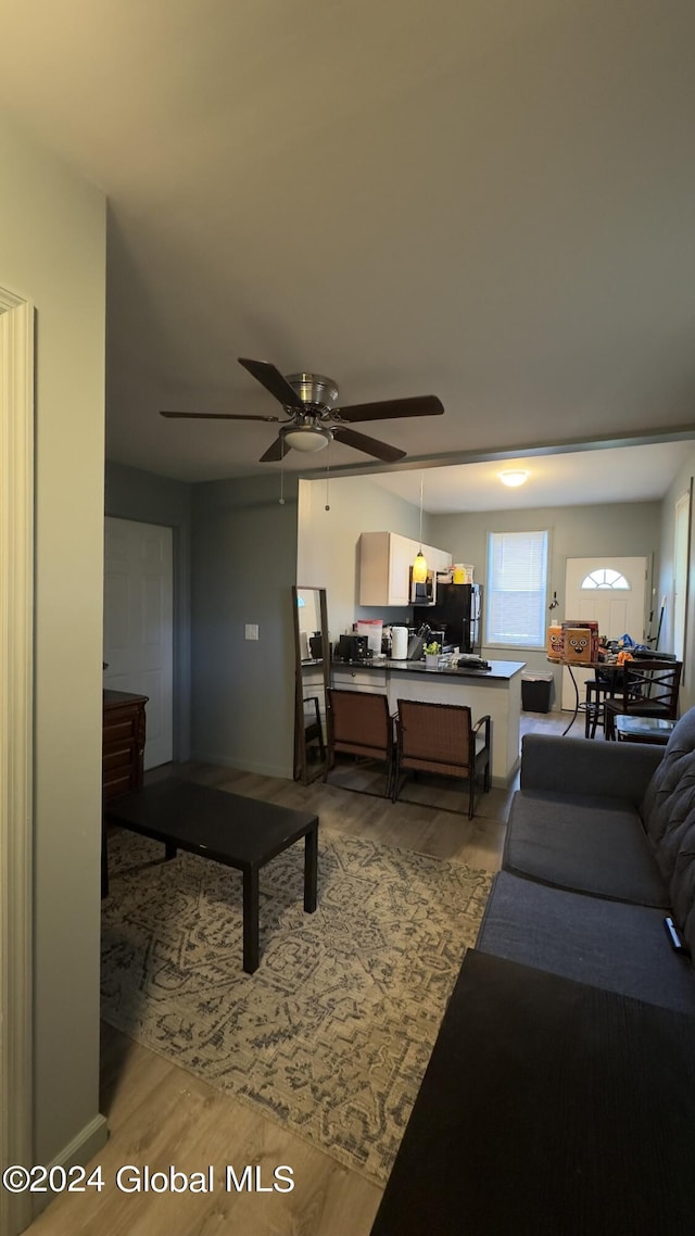 living room featuring ceiling fan and light wood-type flooring