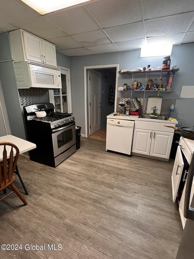 kitchen featuring sink, white cabinets, white appliances, and light hardwood / wood-style flooring