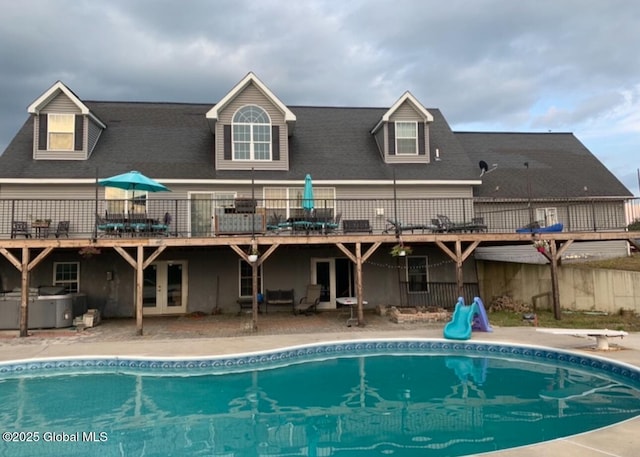 rear view of house with a fenced in pool and a patio area