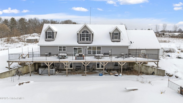 snow covered rear of property featuring a deck