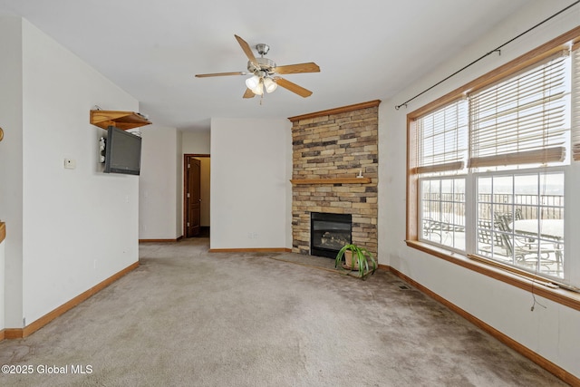 unfurnished living room featuring ceiling fan, a fireplace, and light carpet