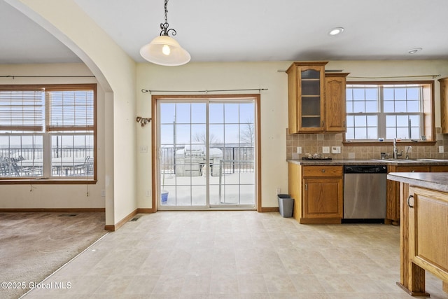 kitchen featuring backsplash, decorative light fixtures, stainless steel dishwasher, and sink