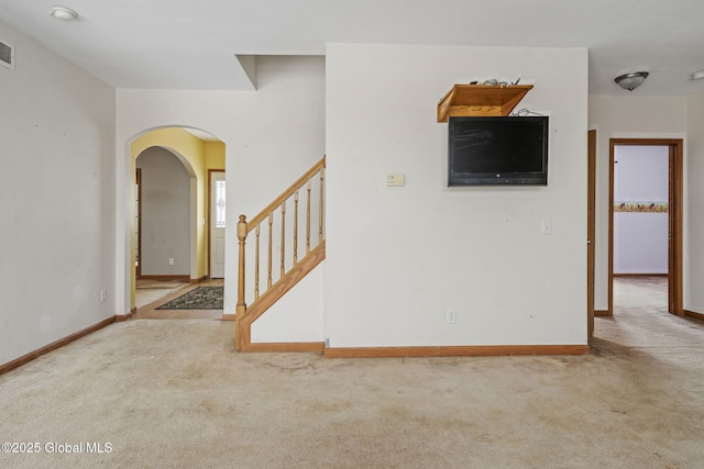 unfurnished living room featuring light colored carpet