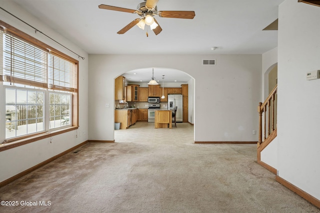 carpeted living room with ceiling fan and sink