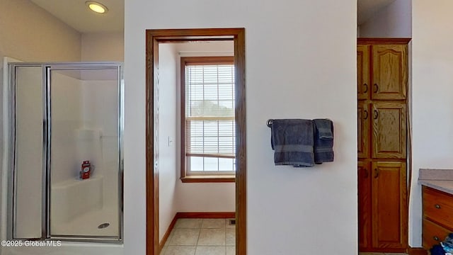 bathroom featuring vanity, a shower with shower door, and tile patterned floors