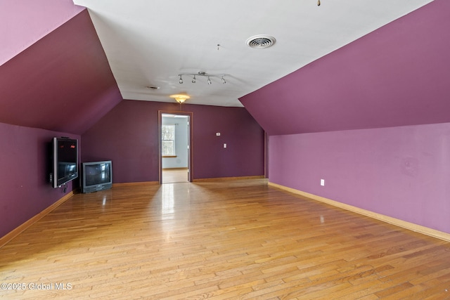 bonus room featuring lofted ceiling and light hardwood / wood-style flooring