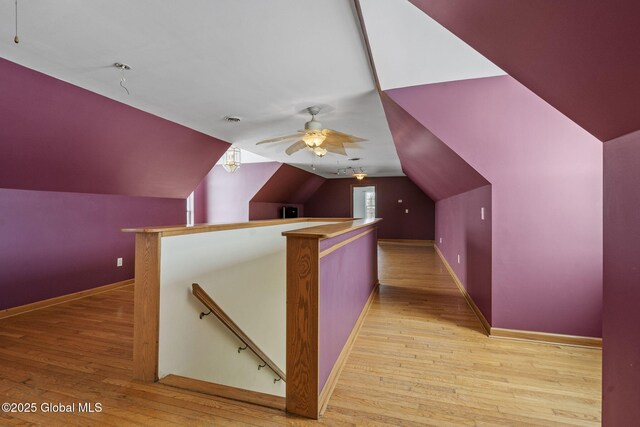 additional living space featuring vaulted ceiling, ceiling fan, and light wood-type flooring