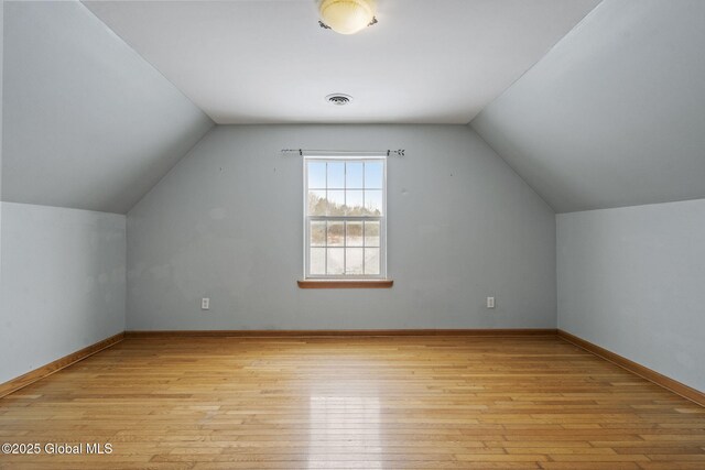 bonus room with lofted ceiling and light hardwood / wood-style floors