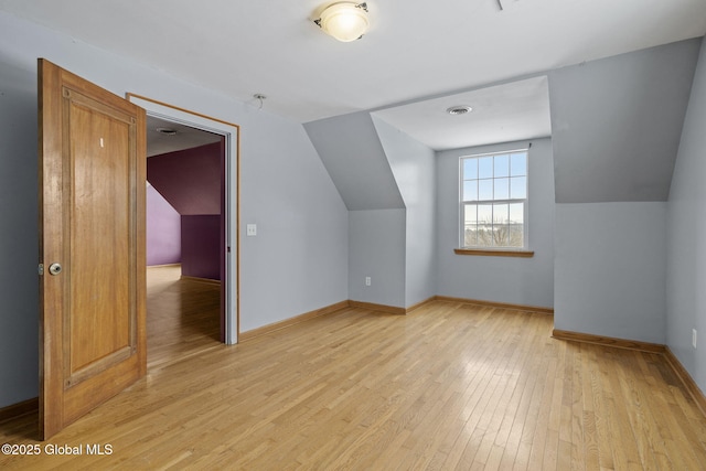 additional living space with lofted ceiling and light hardwood / wood-style flooring