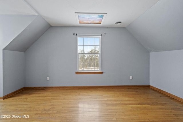 additional living space featuring vaulted ceiling and light hardwood / wood-style floors