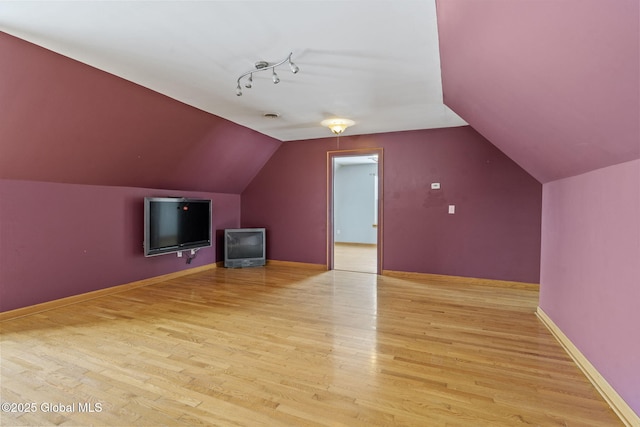 bonus room featuring vaulted ceiling and light wood-type flooring