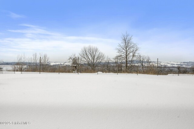 yard covered in snow with a rural view