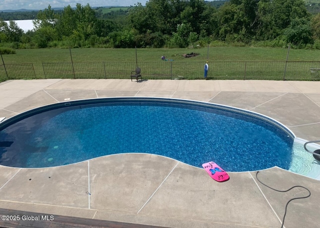 view of pool with a patio and a lawn