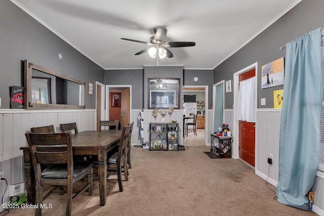 dining room featuring crown molding, ceiling fan, and carpet flooring