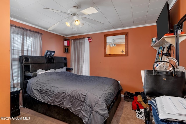 bedroom with ornamental molding, light colored carpet, and ceiling fan