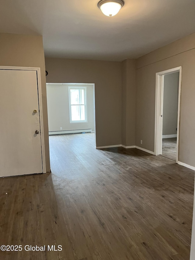 empty room with a baseboard heating unit and dark hardwood / wood-style flooring