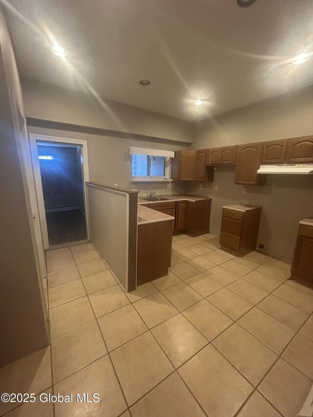 kitchen featuring light tile patterned floors and sink