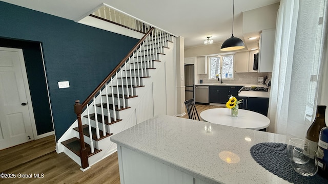 stairs with sink and hardwood / wood-style floors